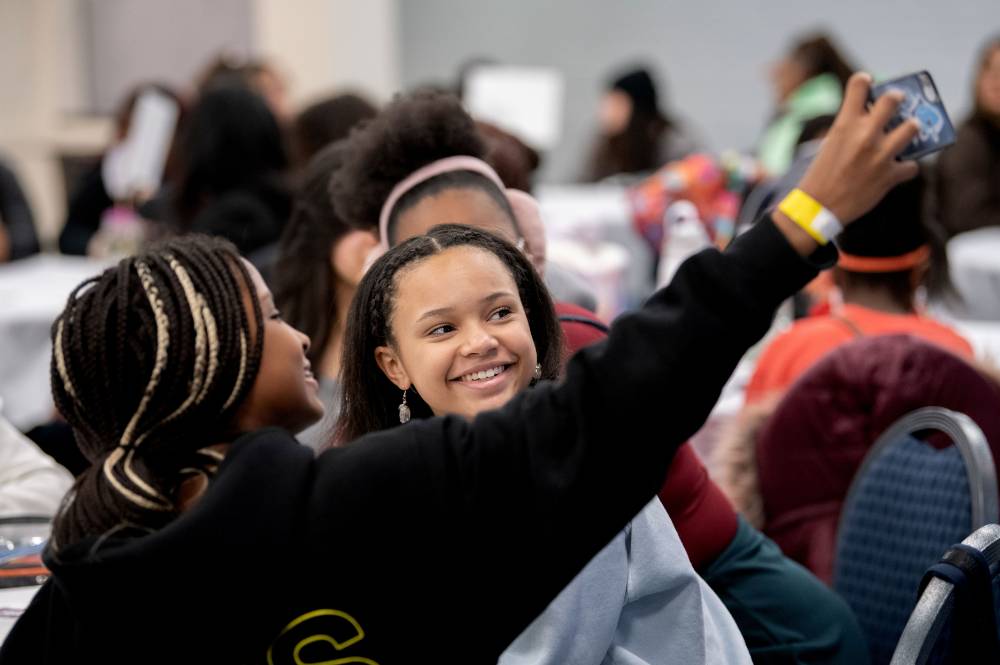 Girls of Color Summit previous event and students taking a selfie at the event